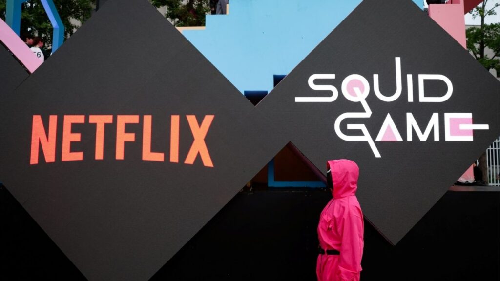 A performer dressed as a 'Squid Game' soldier stands in front of the Netflix and Squid Game logos before a parade through central Seoul, followed by a fan event with cast to celebrate the release of the third season of Netflix's hit series, in Seoul, South Korea, June 28, 2025. (Reuters/Kim Soo-hyeon)