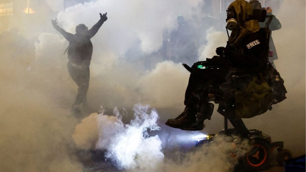 A person gestures amid tear gas as law enforcement officers advance to disperse demonstrators near U.S. Immigration and Customs Enforcement (ICE) headquarters in Portland, Oregon, U.S., October 4, 2025. (Reuters/John Rudoff)