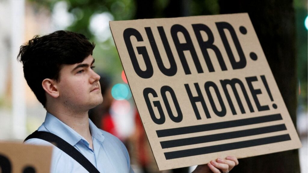 A protestor holds a sign at a rally at Mark O. Hatfield Federal Courthouse, as protestors anticipate a ruling by Federal District Court Judge Karin Immergut regarding President Donald Trump's plan to deploy National Guard members in Portland, in Portland, Oregon, U.S., October 3, 2025. (Reuters File)
