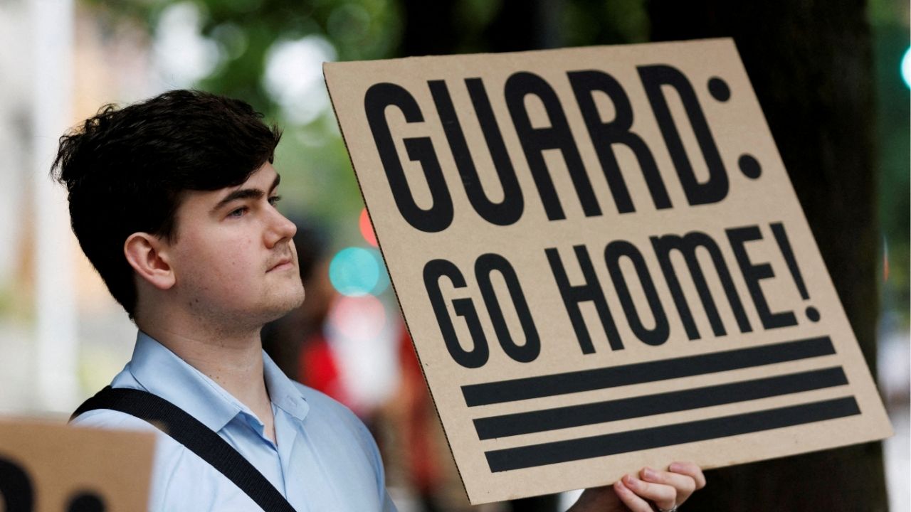 A protestor holds a sign at a rally at Mark O. Hatfield Federal Courthouse, as protestors anticipate a ruling by Federal District Court Judge Karin Immergut regarding President Donald Trump's plan to deploy National Guard members in Portland, in Portland, Oregon, U.S., October 3, 2025. (Reuters File)