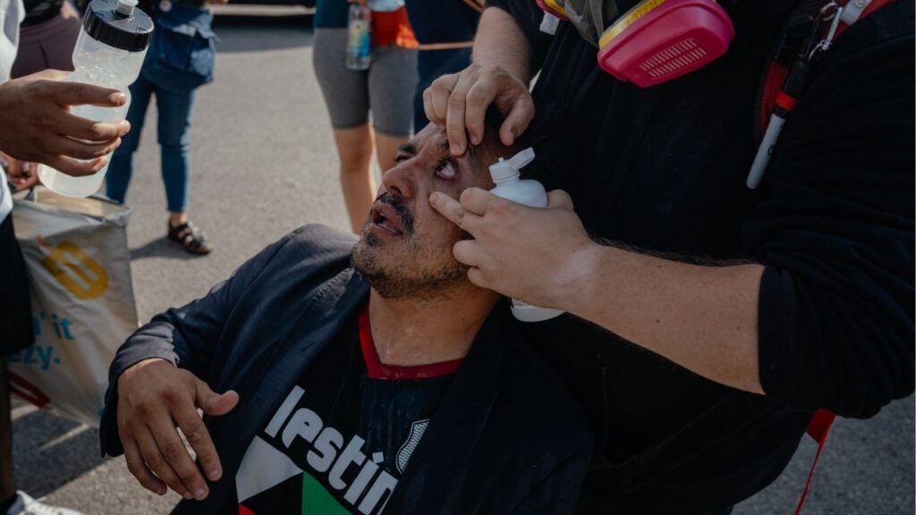 Alderman Byron Sigcho-Lopez has his eyes washed out after federal agents used non-lethal rounds on a crowd of protesters that had gathered following reports that a woman was shot by federal agents in the Brighton Park neighborhood of Chicago on Saturday, Oct. 4, 2025. The repeated use of tear gas by federal immigration officers in Chicago has renewed a debate about how chemical irritants should be used by law enforcement personnel. (Jamie Kelter Davis/The New York Times)