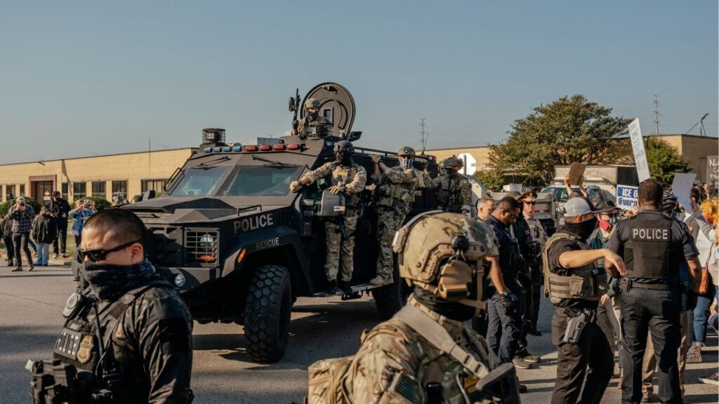 An armored vehicle carrying members of a Immigration and Customs Enforcement Special Response Team pulls up by a crowd of protesters outside of a U.S. Immigration and Customs Enforcement processing facility in Broadview, Ill., on Friday, Oct. 3, 2025. Gov. JB Pritzker of Illinois said on Monday that the state would use every lever at its disposal to fight the Trump administration’s deployment of Texas National Guard troops to the Chicago area, which he labeled an “unconstitutional invasion of Illinois” by the federal government. (Jamie Kelter Davis/The New York Times)