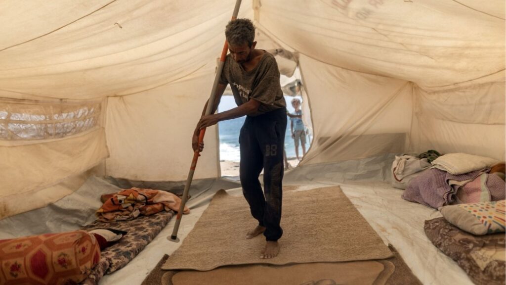 Bassem al-Qedra, 43, the father of six children, pitches a tent after securing a spot at the al-Mawasi camp near Khan Younis, Gaza Strip, on Wednesday, Sept. 17, 2025. Amid the Israeli military’s ground assault on Gaza City, the huge influx of Gazans fleeing to the south has further strained humanitarian services that aid groups say were not sufficient even before the arrival of many thousands more. (Saher Alghorra/The New York Times)