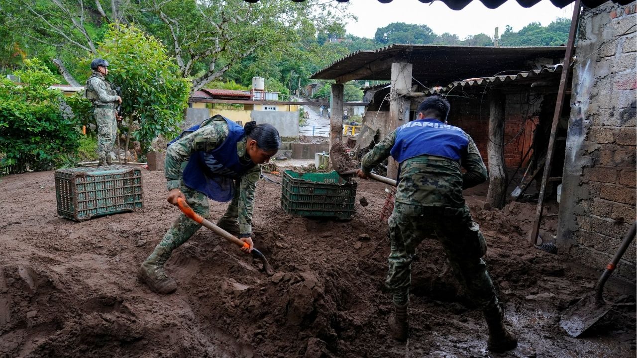 Members of the Mexican navy remove mud from the courtyard of a house as torrential rains from tropical storm Raymond triggered landslides and flooding in Jalcocotan, Nayarit state, Mexico October 12, 2025. (Reuters/Christian Ruano)
