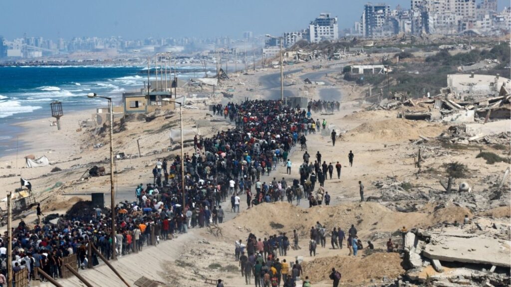 Palestinians, who were displaced to the southern part of Gaza at Israel's order during the war, walk along a road as they attempt to return to the north after a ceasefire between Israel and Hamas in Gaza went into effect, in the central Gaza Strip, October 10, 2025. REUTERS/Mahmoud Issa