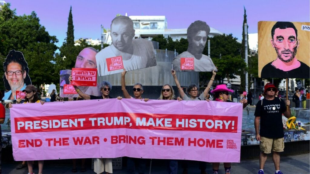 People hold posters of Israeli hostages, and a banner, calling on U.S. President Donald Trump to end the war and return the hostages, on the two-year anniversary of the deadly October 7, 2023 attack on Israel by Hamas from Gaza, in Tel Aviv, Israel, October 7, 2025. (Reuters/Tomer Neuberg)