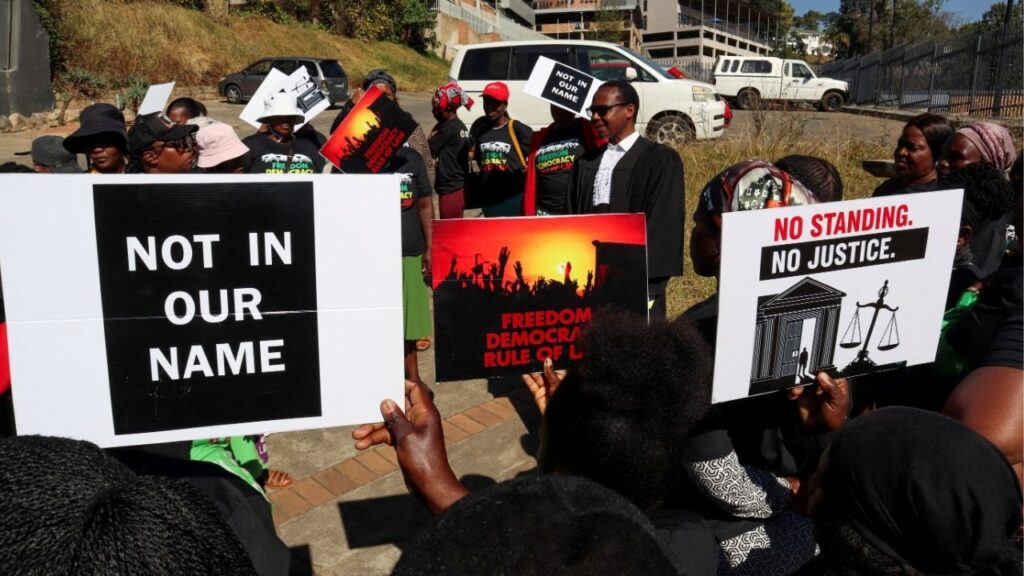 Protesters hold placards as lead applicant and lawyer Mzwandile Masuku addresses them outside the court, after today's hearing was postponed, in Mbabane, Eswatini, August 22, 2025. Activists are challenging a secretive agreement with former U.S. President Donald Trump's administration to accept third-country deportees, which they argue is unconstitutional. (Reuters File)