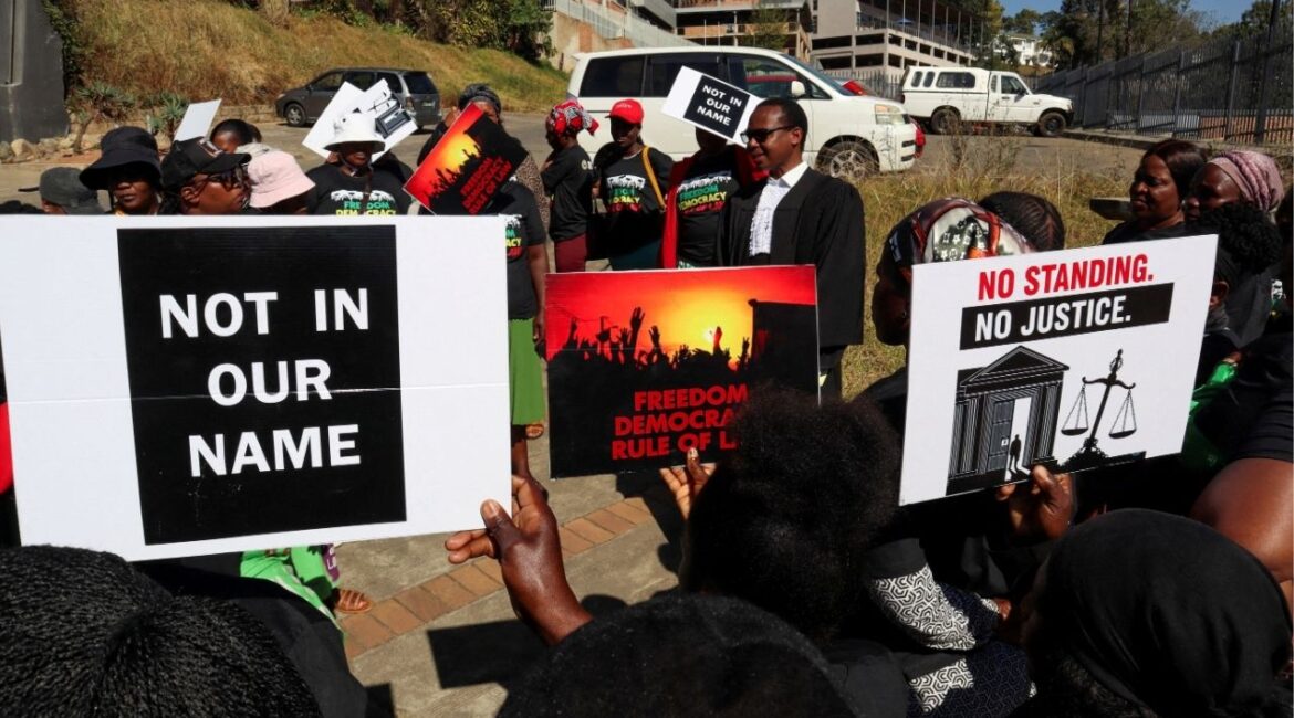Protesters hold placards as lead applicant and lawyer Mzwandile Masuku addresses them outside the court, after today's hearing was postponed, in Mbabane, Eswatini, August 22, 2025. Activists are challenging a secretive agreement with former U.S. President Donald Trump's administration to accept third-country deportees, which they argue is unconstitutional. (Reuters File)