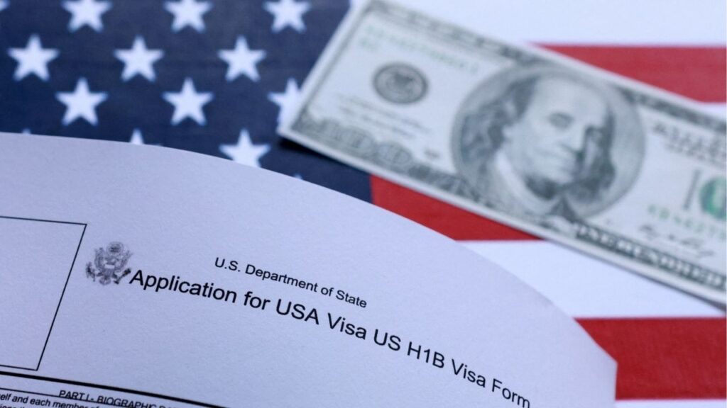 U.S. flag, mock passport, 100 dollar banknote and H-1B visa application form are seen in this illustration taken September 26, 2025. (Reuters/Dado Ruvic/Illustration)