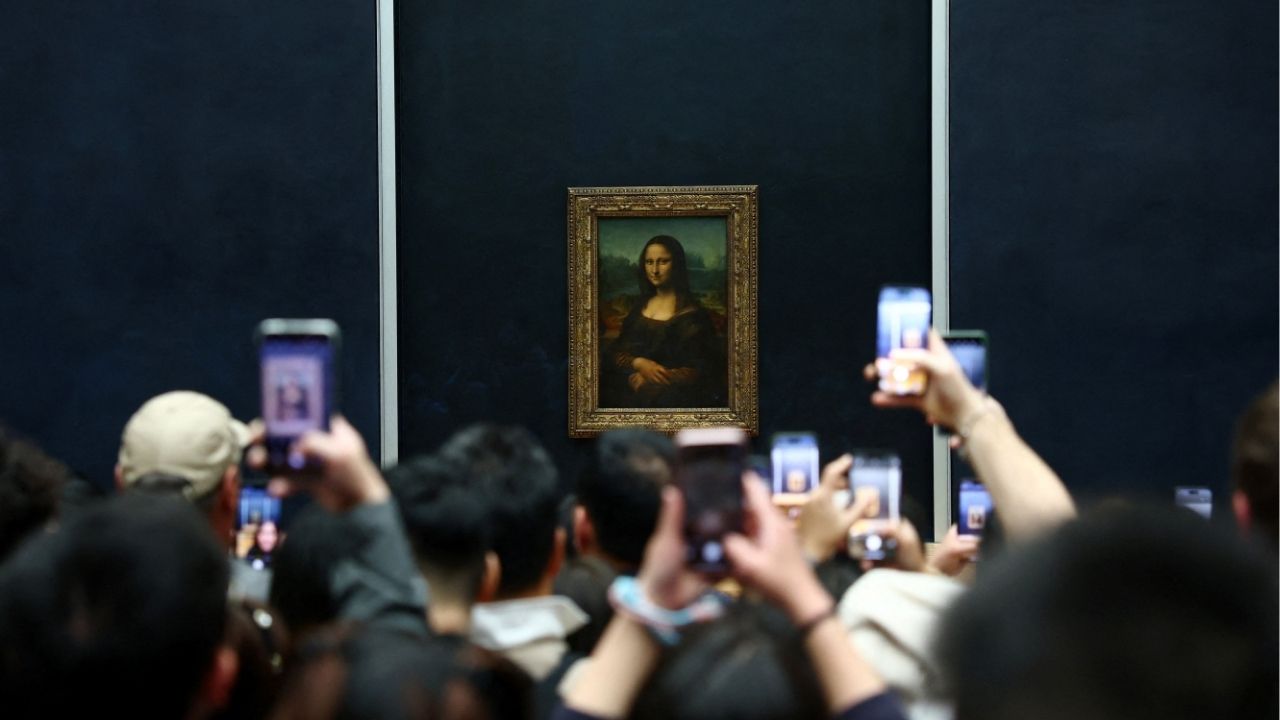 Visitors take pictures of the painting "Mona Lisa" (La Joconde) by Leonardo da Vinci at the Louvre Museum on the day it reopened to the public for the first time since last Sunday's heist, while the Galerie d'Apollon where eight pieces of Napoleon and the Empress's jewelry collection displayed in the gallery were stolen by thieves, remains closed, in Paris, France, October 22, 2025. (Reuters/Gonzalo Fuentes)
