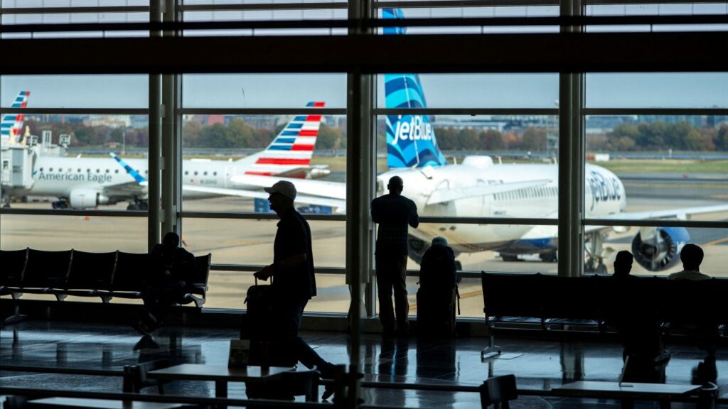 Image of Travelers walk though Ronald Reagan Washington National Airport as the Trump administration warns of impending cuts to commercial airline operations more than a month into the continuing U.S. government shutdown in Arlington, Virginia, U.S., November 7, 2025.