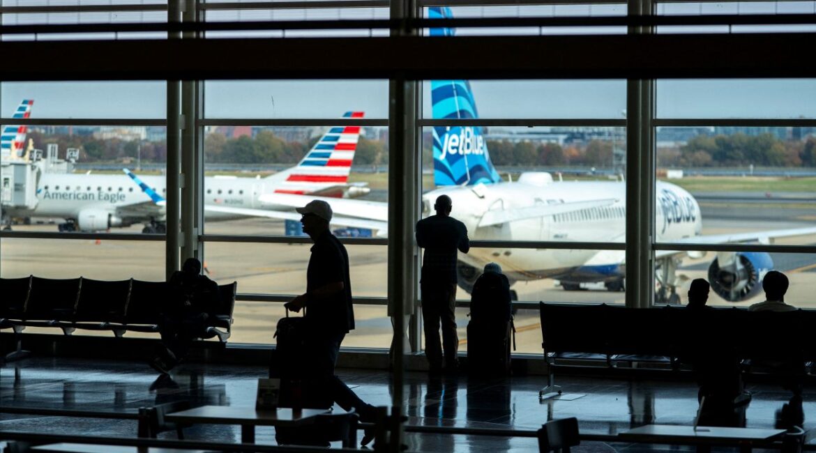 Image of Travelers walk though Ronald Reagan Washington National Airport as the Trump administration warns of impending cuts to commercial airline operations more than a month into the continuing U.S. government shutdown in Arlington, Virginia, U.S., November 7, 2025.