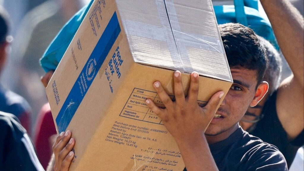 A Palestinian carries aid supplies that entered Gaza, amid a ceasefire between Israel and Hamas in Gaza, in Zawaida in the central Gaza Strip. (Reuters/Mahmoud Issa)
