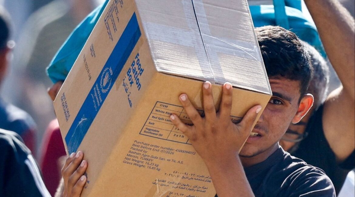 A Palestinian carries aid supplies that entered Gaza, amid a ceasefire between Israel and Hamas in Gaza, in Zawaida in the central Gaza Strip. (Reuters/Mahmoud Issa)