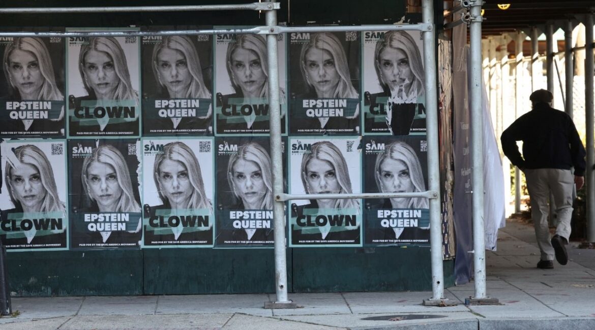 A man walks by posters of U.S. Attorney General Pam Bondi labelled as “Epstein queen” and “clown” as the U.S. House of Representatives is expected to vote as soon as Tuesday to force the release of investigative files related to the late convicted sex offender Jeffrey Epstein, in Washington, D.C., U.S., November 17, 2025. (Reuters/Kevin Lamarque)
