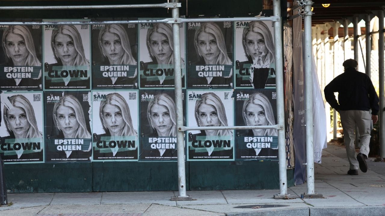 A man walks by posters of U.S. Attorney General Pam Bondi labelled as “Epstein queen” and “clown” as the U.S. House of Representatives is expected to vote as soon as Tuesday to force the release of investigative files related to the late convicted sex offender Jeffrey Epstein, in Washington, D.C., U.S., November 17, 2025. (Reuters/Kevin Lamarque)