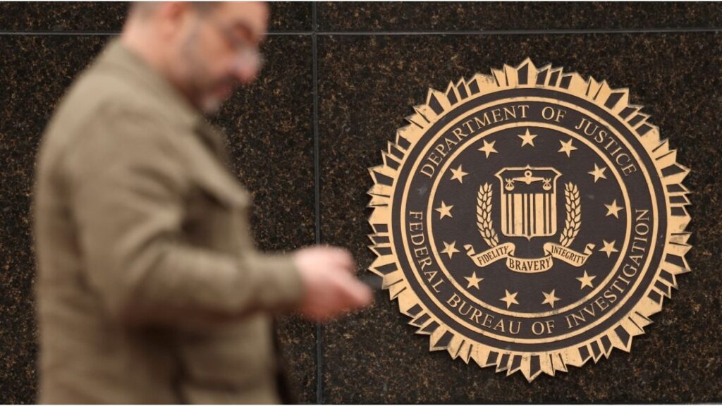 A person passes by the FBI seal on the wall of the FBI headquarters in Washington, U.S., February 3, 2025. (Reuters/Kevin Lamarque)