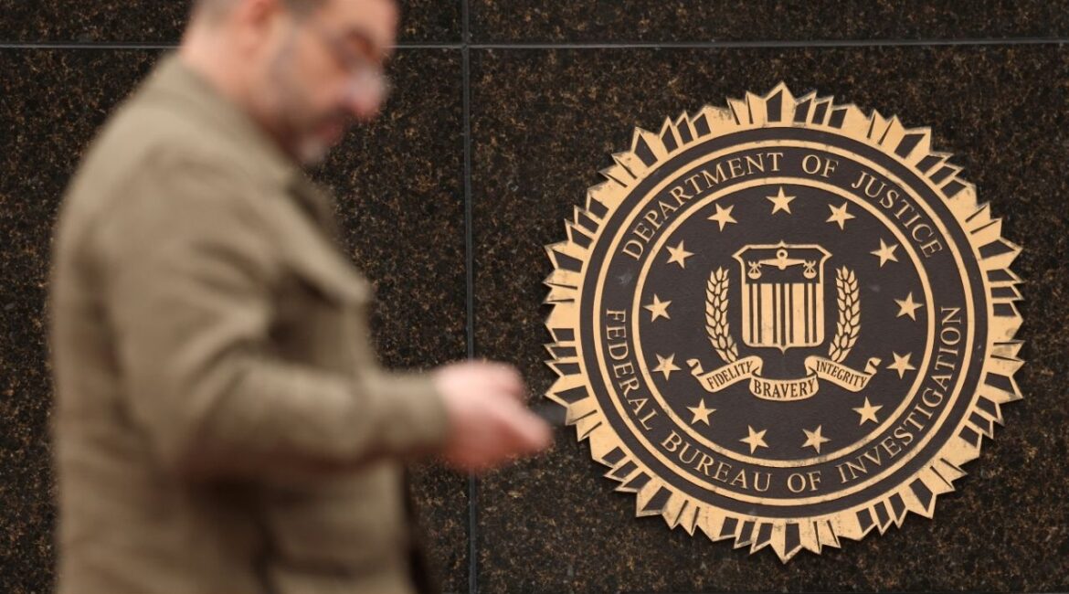 A person passes by the FBI seal on the wall of the FBI headquarters in Washington, U.S., February 3, 2025. (Reuters/Kevin Lamarque)