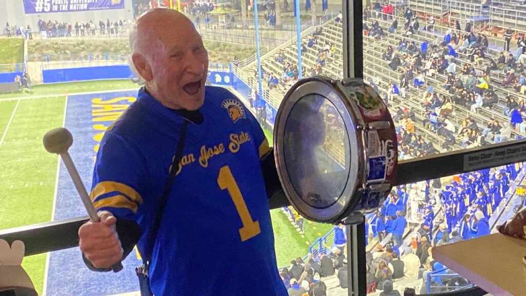 Image of cheerleader Krazy George banging his drum inside the press box at San Jose State's football stadium