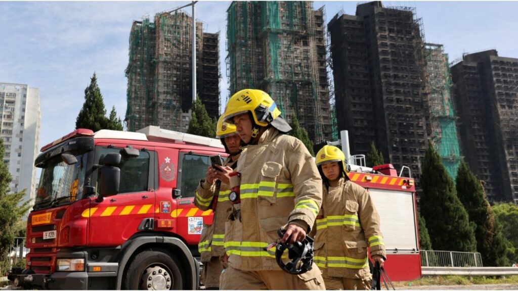 Firefighters walk near the site of a major fire at Wang Fuk Court housing complex, where flames engulfed bamboo scaffolding across multiple blocks, in Tai Po, Hong Kong, China, November 28, 2025. (Reuters/Tyrone Siu)