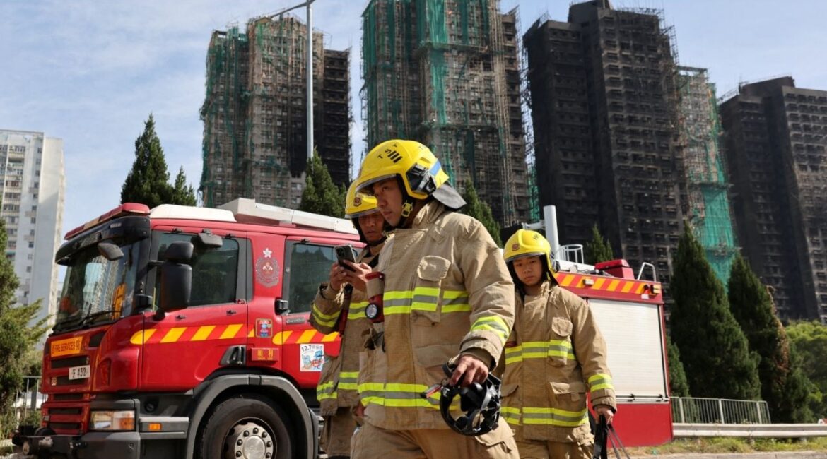 Firefighters walk near the site of a major fire at Wang Fuk Court housing complex, where flames engulfed bamboo scaffolding across multiple blocks, in Tai Po, Hong Kong, China, November 28, 2025. (Reuters/Tyrone Siu)