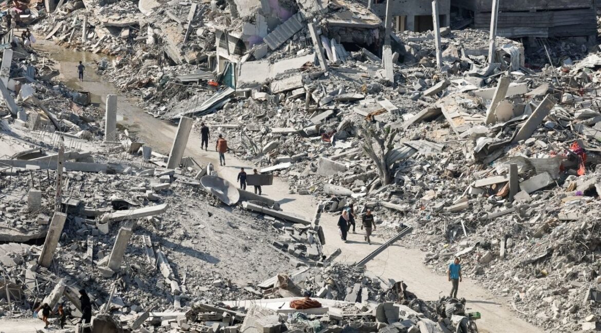 Palestinians walk past the rubble of destroyed buildings, amid a ceasefire between Israel and Hamas, in Gaza City, November 2, 2025. (Reuters/Mahmoud Issa)