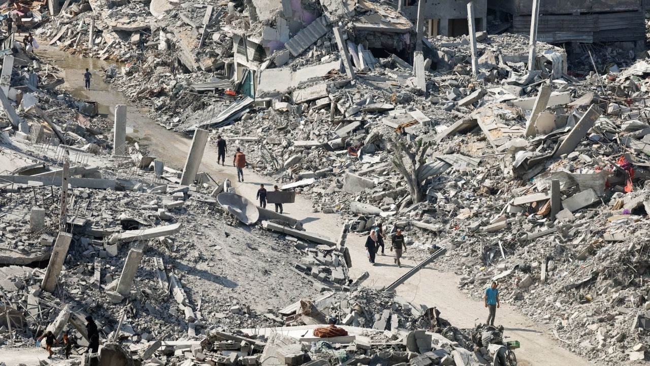 Palestinians walk past the rubble of destroyed buildings, amid a ceasefire between Israel and Hamas, in Gaza City, November 2, 2025. (Reuters/Mahmoud Issa)