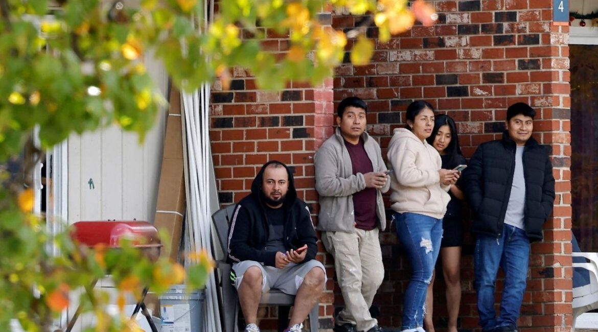 Residents of a largely Hispanic neighborhood watch a gathering of fellow community members and activists across the street from the site of a concluded raid by federal authorities as they expand their crackdown on illegal immigration, in Raleigh, North Carolina, U.S., November 18, 2025. (Reuters/Jonathan Drake)