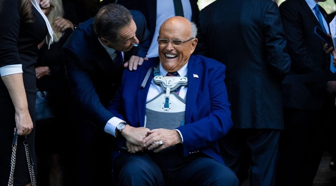 Rudy Giuliani, seated, a former New York City mayor and lawyer for President Donald Trump, shares a laugh with former Gov. ANdrew Como of New York, then an independent candidate for mayor, at a commemoration ceremony on the anniversary of the 9/11 attacks in lower Manhattan on Sept. 11, 2025. Trump has granted pre-emptive pardons to Giuliani and others accused of trying to overturn the results of the 2020 presidential election, according to an official familiar with the matter. (Vincent Alban/The New York Times)