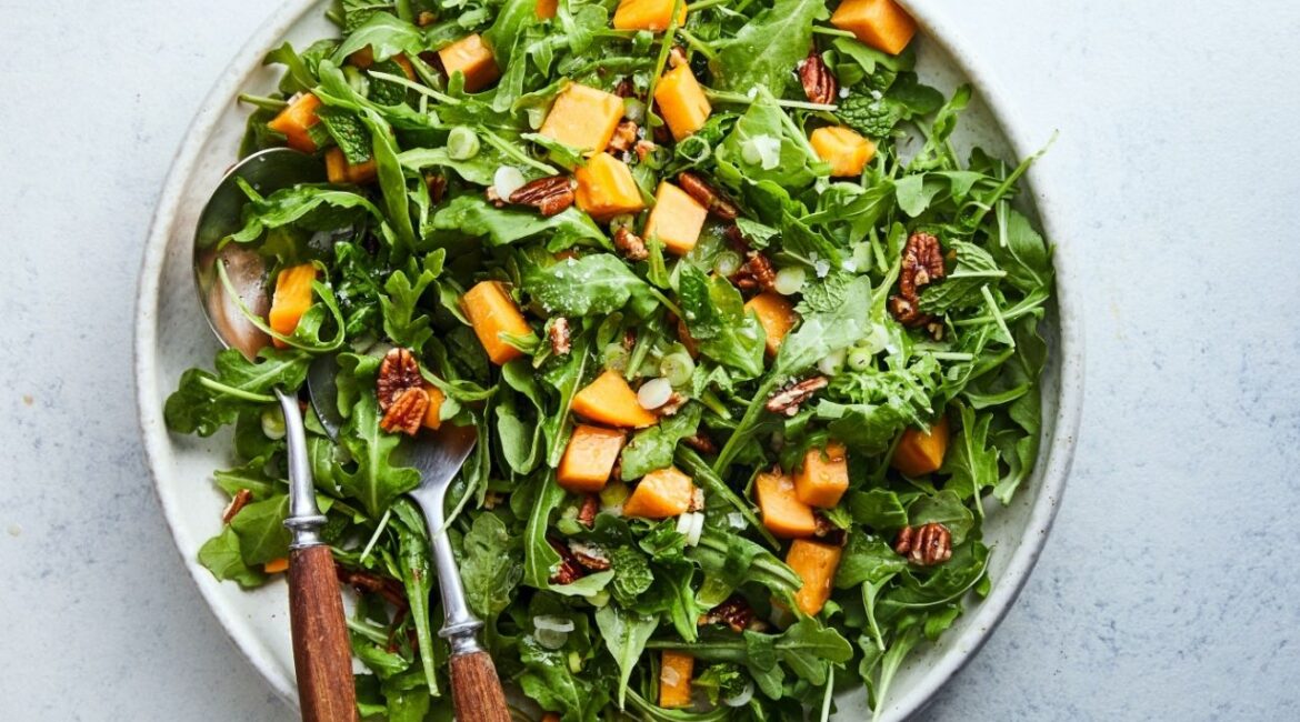 Sean Sherman’s wild greens salad with persimmons and hickory nuts. Food Stylist: Monica Pierini. (Linda Xiao/The New York Times)