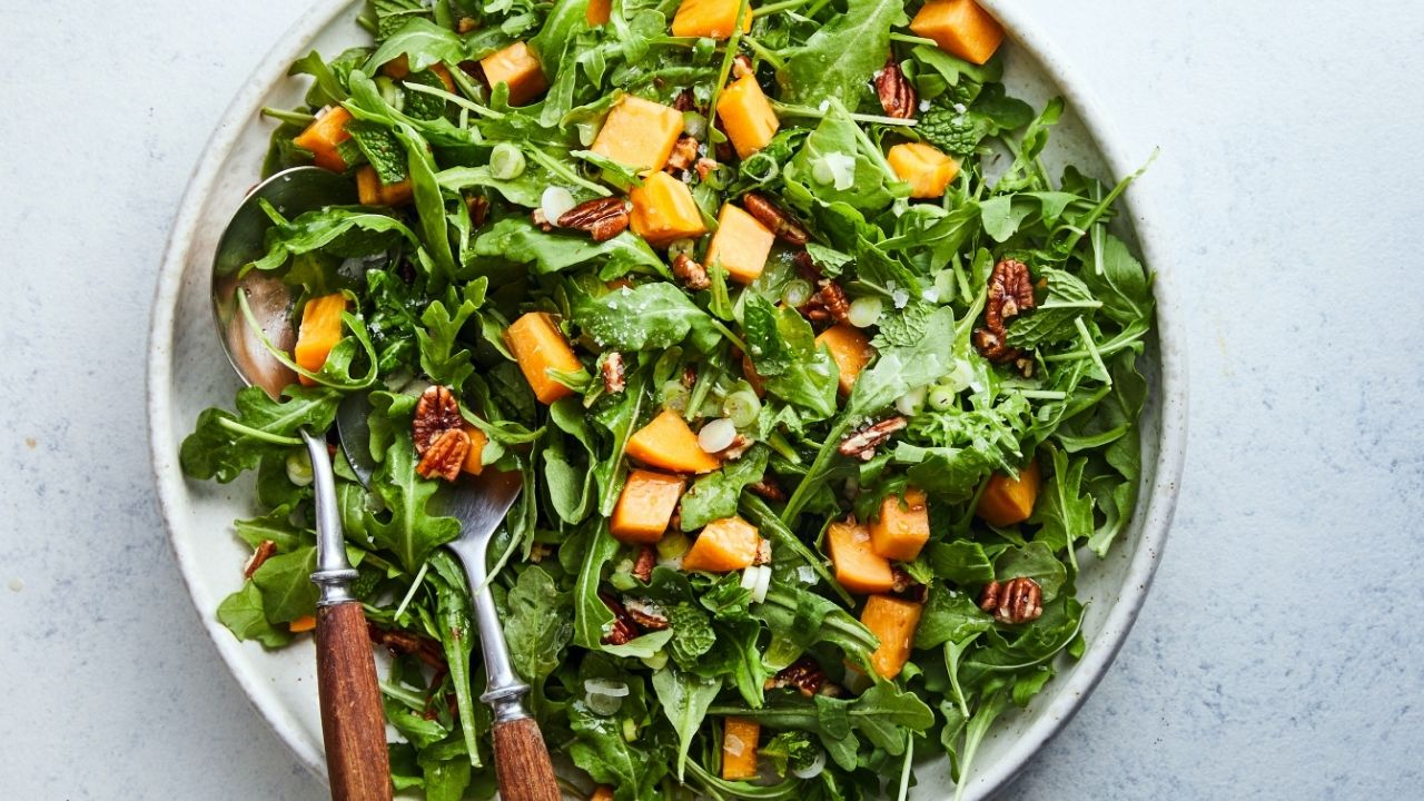 Sean Sherman’s wild greens salad with persimmons and hickory nuts. Food Stylist: Monica Pierini. (Linda Xiao/The New York Times)