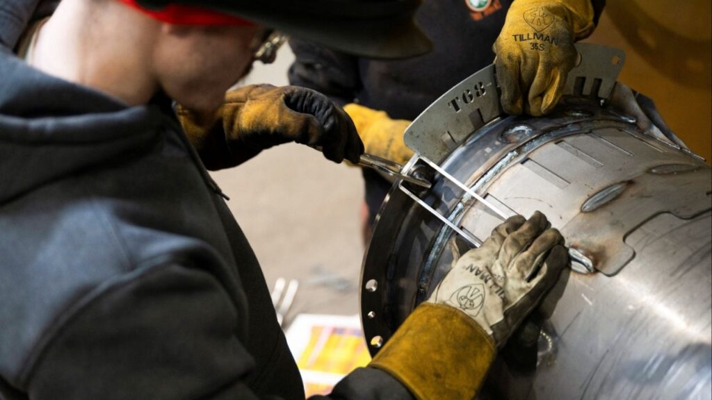 Workers prepare to weld a steel tube at HCC, a company that uses parts to make combines, at the factory in Mendota, Illinois, U.S., February 21, 2025. (Reuters/Vincent Alban)