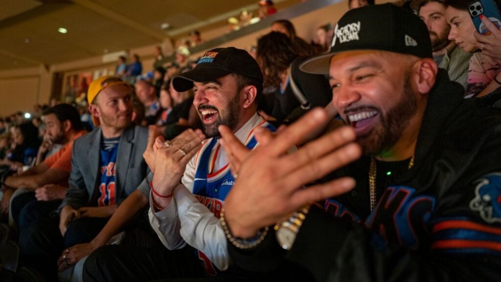 Zohran Mamdani, the Democratic nominee for New York City Mayor, center, attends a New York Knicks basketball game with Joel Armogasto Martinez, also known as The Kid Metro, in New York, on Sunday, Nov. 2, 2025. Mamdani’s low-key appearance at Madison Square Garden underscored the accessibility and relatability he has tried to convey as a candidate. (Jonah Markowitz/The New York Times)