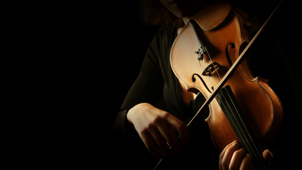 Image of a hand with a bow playing a violin surrounded by darkness
