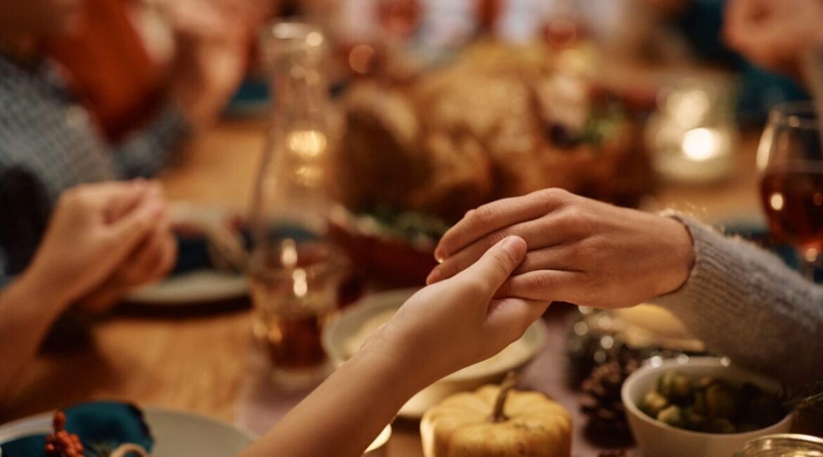 Image of hands touching over Thanksgiving Dinner