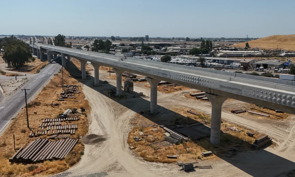 Image of a concrete high-speed rail ramp under construction and pipes on the ground below