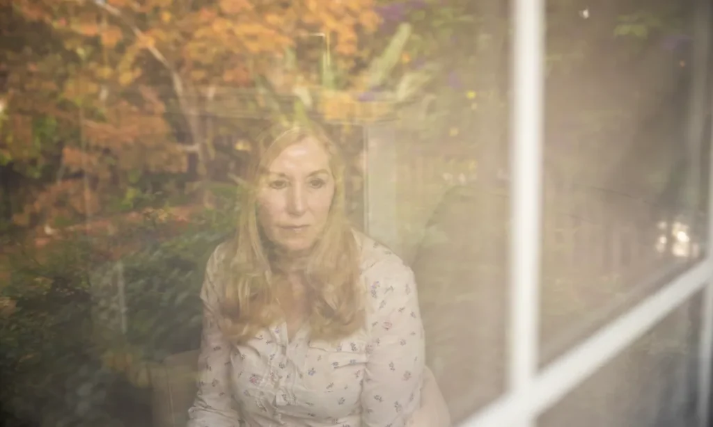 Image of a woman peering through a window on a fall day in California