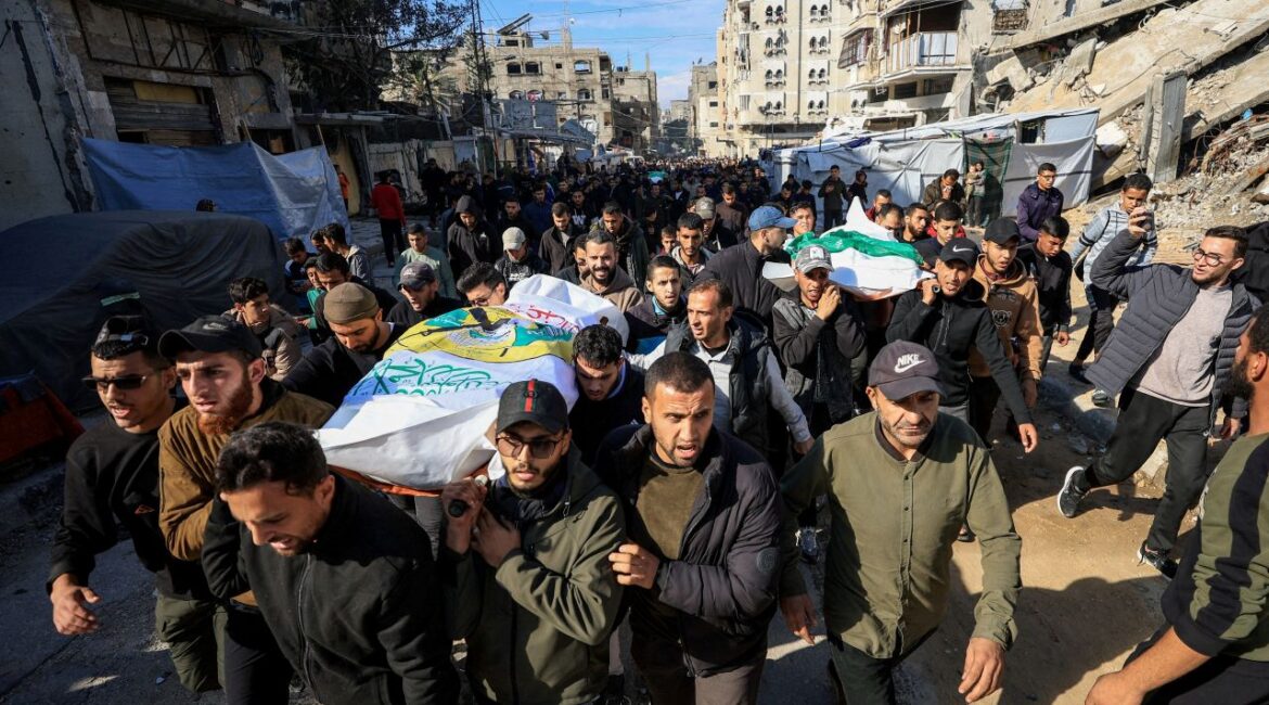Image of Palestinian mourners carrying the sheath-wrapped body of a senior Hamas commander during his funeral.