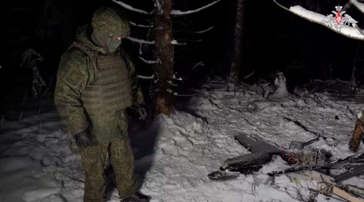 A Russian service member stands next to the remains of a drone, which, according to the Russian Defence Ministry, was downed during the repelling of an alleged Ukrainian attack on the Russian presidential residence in the Novgorod Region, in an unknown location in Russia, in this still image from a video released December 31, 2025. Russian Defence Ministry/Handout via REUTERS