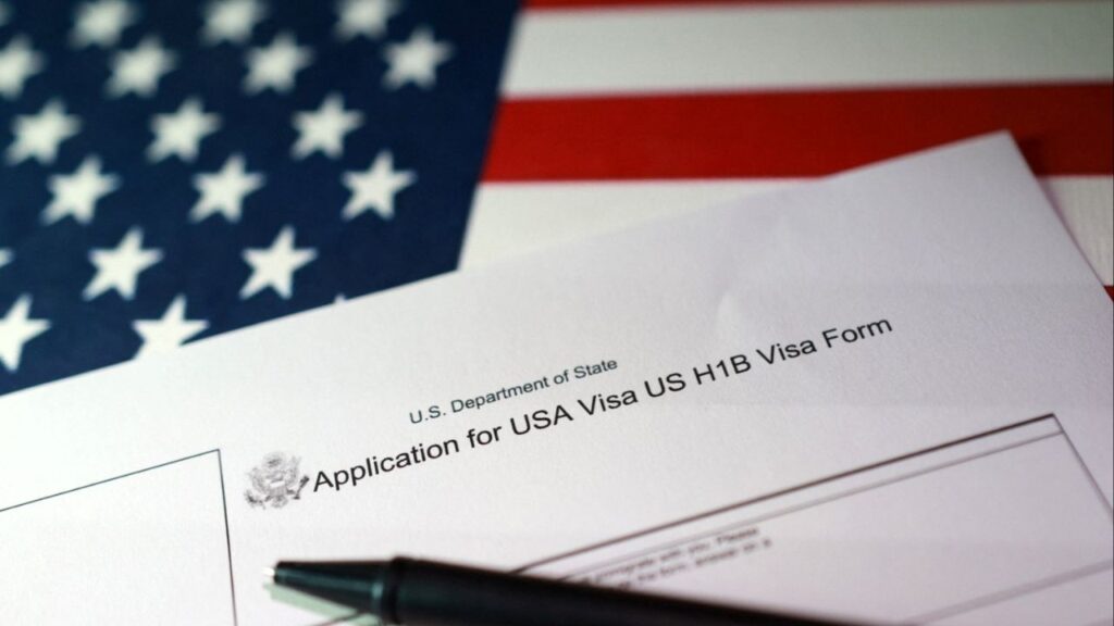 A U.S. flag and a U.S. H-1B Visa application form are seen in this illustration taken, September 22, 2025. (Reuters/Dado Ruvic/Illustration)