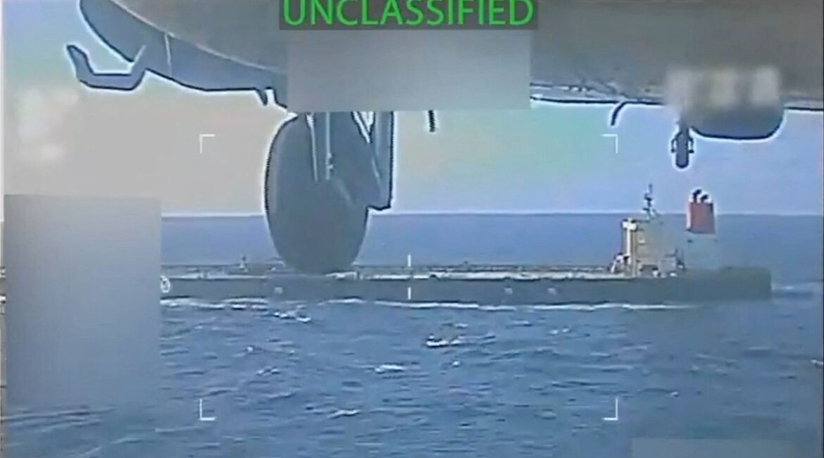 A U.S. military helicopter flies near an oil tanker during a raid described by U.S. Attorney General Pam Bondi as its seizure by the United States off the coast of Venezuela, December 10, 2025, in a still image from video. (U.S. Attorney General/Handout via Reuters)