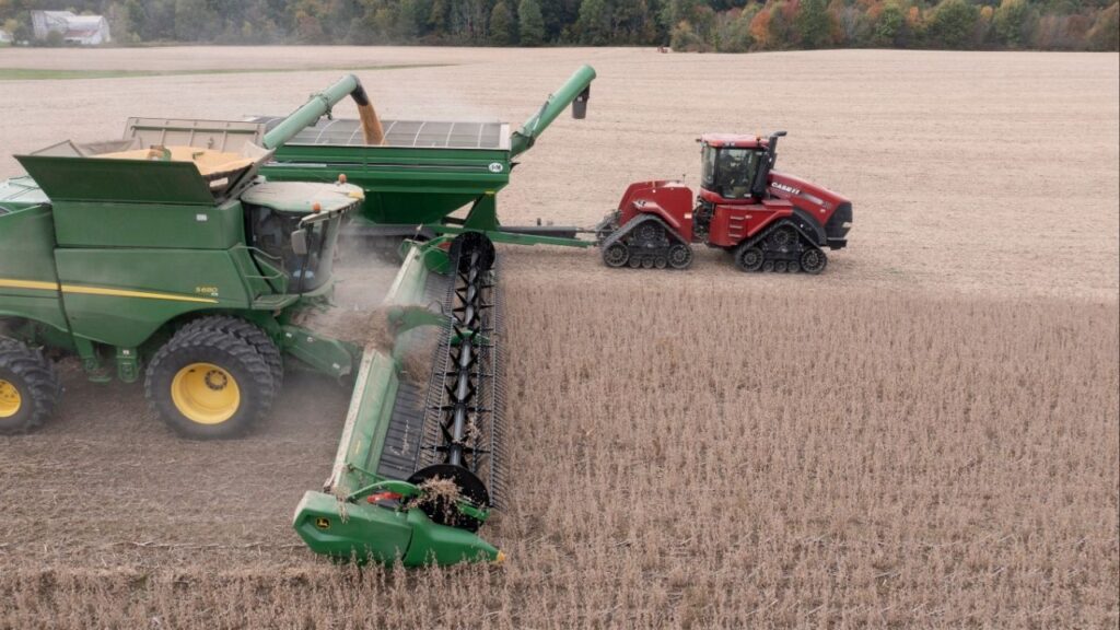 A combine harvester is seen as it harvests soybeans while loading a grain transfer hoper in Deerfield, Ohio, U.S., October 7, 2021. Picture taken with a drone. Picture taken October 7, 2021. (Reuters/Dane Rhys)