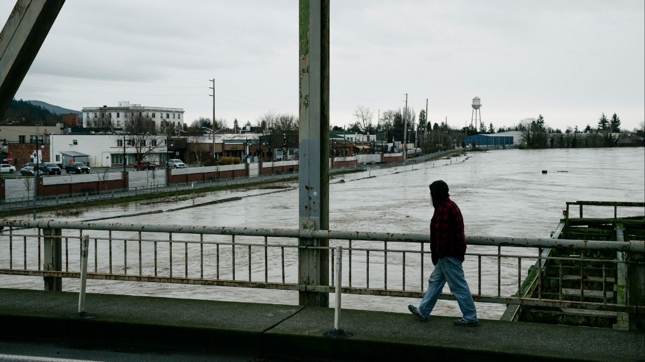 A man crosses the Division Street Bridge as the rising Skagit River passes near downtown Mount Vernon, Wash., on Thursday, Dec. 11, 2025. The river is forecast to crest on Friday morning after several days of heavy rain pushed waterways in the region to record levels. (Grant Hindsley/The New York Times)