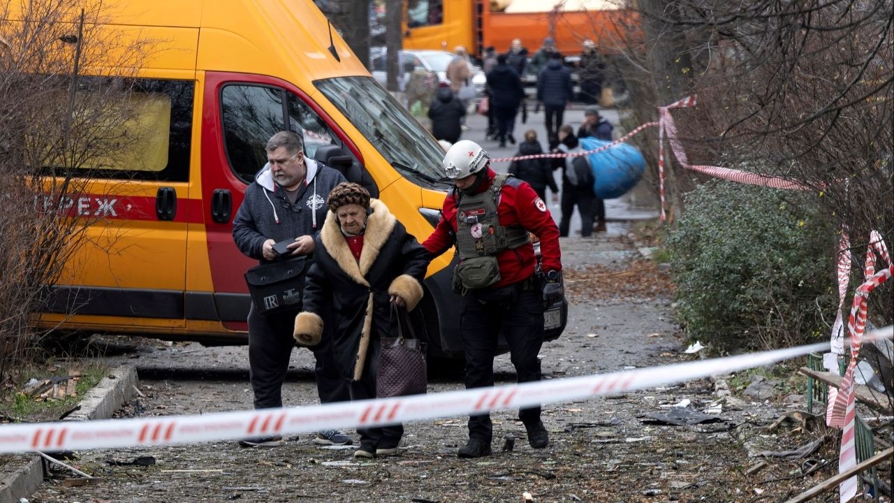 A medic assists a resident as she leaves her apartment building that was hit by a Russian drone, amid Russia's attack on Ukraine, in Kyiv, Ukraine December 23, 2025. (Reuters/Thomas Peter)