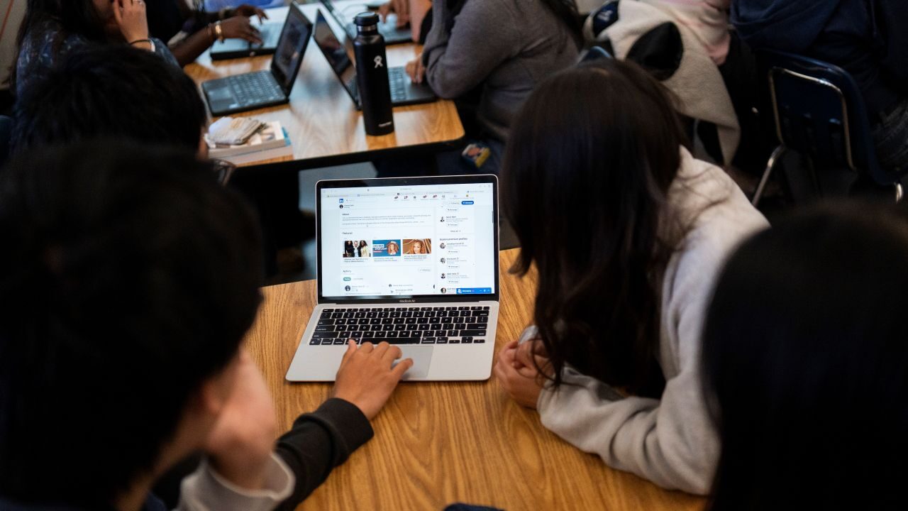 Image of students checking social media information on a laptop