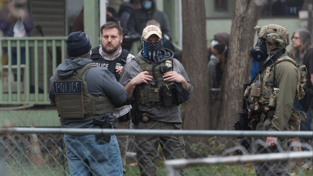 Federal officers from ICE and other agencies stand guard during an immigration raid of a home in St. Paul, Minnesota, U.S. November 25, 2025. (Reuters/Tim Evans)
