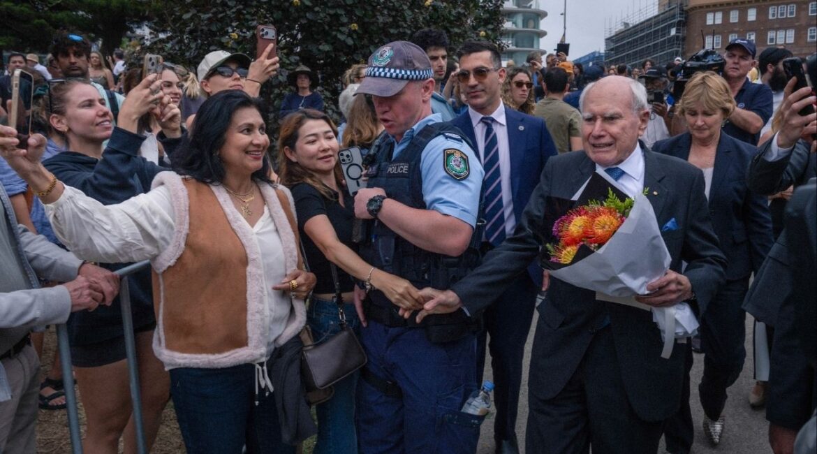 Former Prime Minister John Howard, who led Australia at the time of the Port Arthur massacre and moved swiftly to enact new laws and gun buybacks, brings flowers to a memorial at Bondi Beach in Sydney, on Tuesday, Dec. 16, 2025. Sunday’s mass shooting at a Hanukkah celebration, carried out by two gunmen with half a dozen legally obtained long guns, has chipped away at Australians’ long-held comfort in their country’s strict gun control laws. (Matthew Abbott/The New York Times)