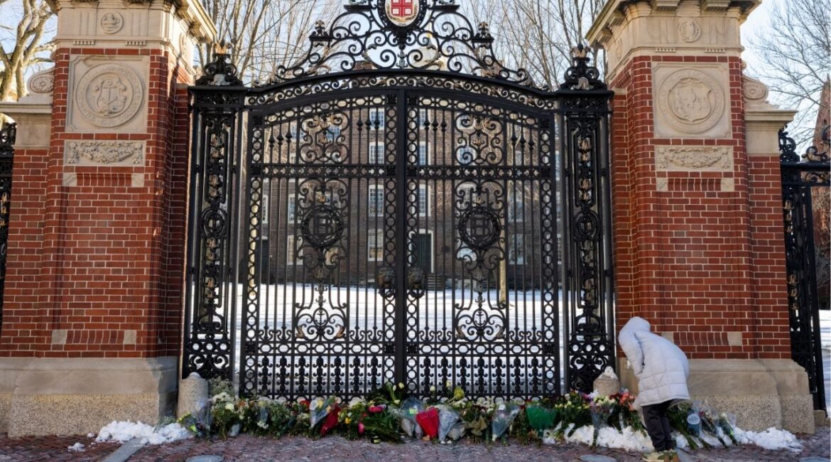 Hannah Chen, a junior at Brown University, leaves flowers at the Van Wickle Gates at the Brown University campus in Providence, R.I., on Monday, Dec. 15, 2025. The authorities on Thursday identified a person of interest in the shooting at Brown University and are investigating whether there is a possible connection to the killing of a Massachusetts Institute of Technology professor, according to a law enforcement official who was briefed on the matter but was not authorized to speak about the investigation. (Christopher Capozziello/The New York Times)