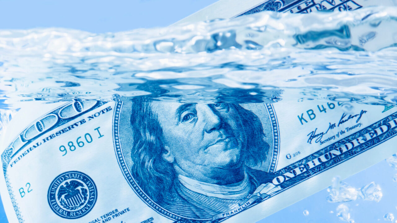 Image of a $100 bill floating in water with a sparkling blue hue