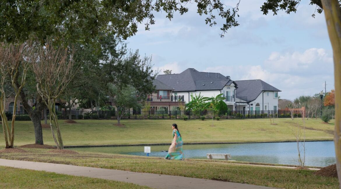 An Indian American woman walks near at lake in a beautiful neighborhood in Sugar Land, Texas